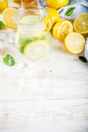 Homemade sour cocktail lemonade, with fresh lemons, mint and honey, white wooden background copy spaceの写真素材