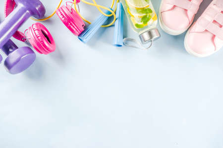 Sport and fitness creative layout, dumbbells, women's sneakers, jump rope, notebook, bottle with...