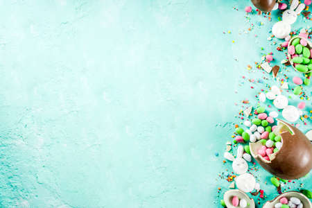 Colorful spring easter sweets background, with chocolate eggs, sugar sprinkles and marshmallow...