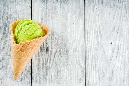 Colorful ice cream in waffle ice cream cones, sweet homemade summer dessert, old wooden background copy space top viewの写真素材