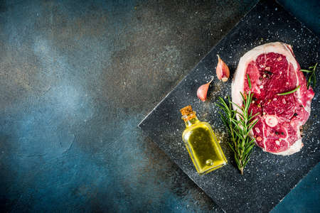 Raw meat, beef or lamb steak with bone, for grilling, with spices and herbs, top view place for text