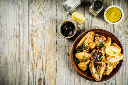 Grilled bbq chicken wings with sauces and spices, wooden background copy space top viewの写真素材