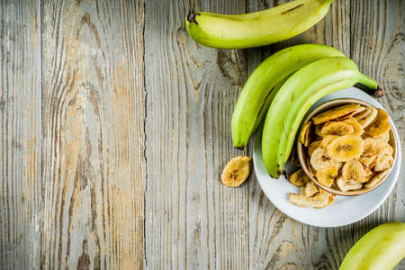 Dried bananas plantains with fresh bananas, wooden background copy spaceの写真素材