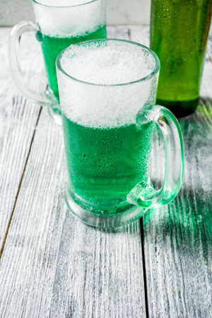 St. Patrick's day concept, two glasses and bottle with cold fresh cold green beer on wooden table, bar counter Background for St. Patrick's day and Oktoberfest menu. Copy spaceの写真素材
