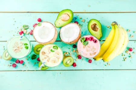 Summer refreshing drinks - protein shakes, milkshakes or smoothies, with fresh berry and fruits, light blue table copy spaceの写真素材