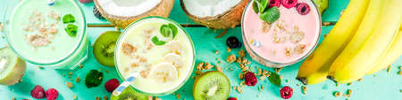 Summer refreshing drinks - protein shakes, milkshakes or smoothies, with fresh berry and fruits, light blue table copy space bannerの写真素材