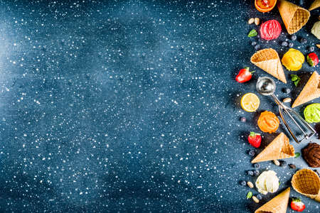 Colorful fruit and berry, nut, chocolate and vanilla ice cream, with waffle ice-cream cones, with...