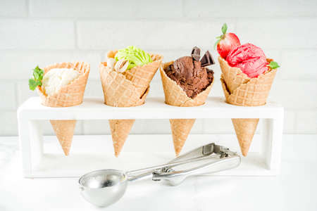 Colorful fruit and berry, nut, chocolate and vanilla ice cream, with waffle ice-cream cones, with...