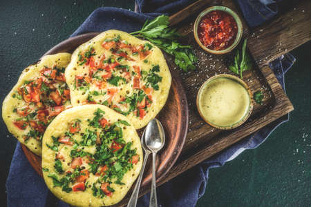 Indian traditional food recipes, Uttapam oats or semolina pancakes with fresh vegetables and herbs, dark blue background copy space top viewの写真素材