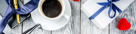 Fathers day greeting background with coffee cup and presents on wooden table copy space top view...