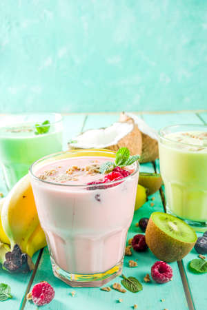 Summer refreshing drinks - protein shakes, milkshakes or smoothies, with fresh berry and fruits, light blue table copy spaceの写真素材