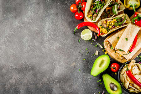 Cinco de Mayo food.Mexican food concept background with taco, quesadilla, burrito, chili, salsa sauce, hot pepper, lime. Black concrete background top view copy spaceの写真素材