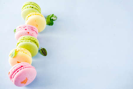 Classic colorful macarons. Six pink, yellow and green macaron cookies top view copy space