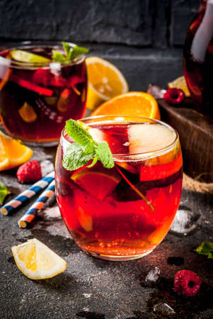 Summer cold cocktail, fruit and berry red wine sangria with apple, lemon, oranges and raspberry. dark background, copy spaceの写真素材