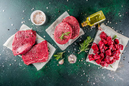 Various raw beef meat with spices and herbs, dark concrete background copy spaceの写真素材