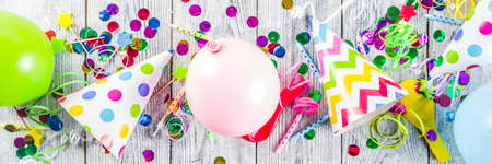 Birthday party decoration background with balloons, gift boxes, steamers and confetti, wooden white table copy space above bannerの写真素材