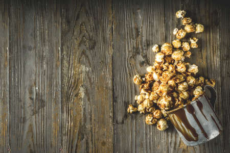 Homemade sweet caramel pop corn, with caramel topping, dark rustic background copy spaceの写真素材