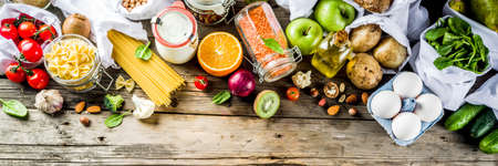 Zero waste shopping and sustanable lifestyle concept, various farm organic vegetables, grains, pasta, eggs and fruits in reusable packaging supermarket bags. copy space top view, bannerの写真素材