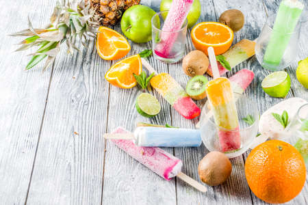 Colorful fruit ice cream popsicle. Juicy gelato lollypops on sticks, with different fresh tropic...