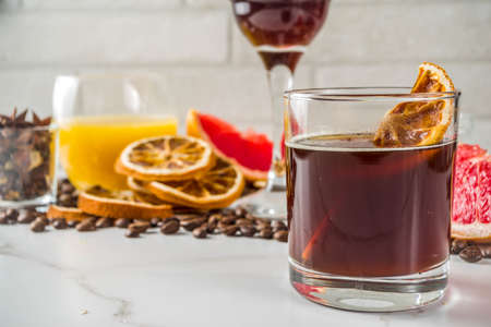Negroni coffee cocktail with ingredients - coffee, orange, grapefruit, spices, liqueur, white marble...