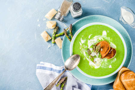 Healthy homemade asparagus vegetable cream soup in a bowl on light blue slate, stone or concrete background. Copy space.の写真素材