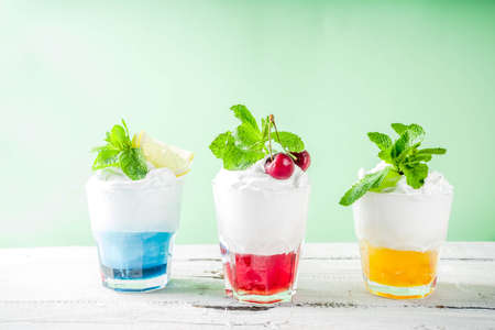 Summer cold drinks. Colorful Italian cream soda cocktails over white wooden background copy spaceの写真素材