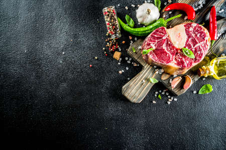Raw ossobuco meat, beef steak with spices for cooking, black stone concreteの写真素材