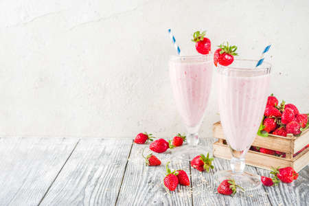 Healthy food and drinks. Strawberry smoothie or milkshake with fresh berries on a wooden whiteの写真素材