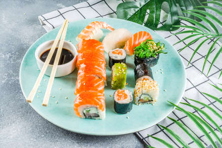 Assorted sushi set on stone or concrete background.  Japanese classic sushi, sushi nigiri. rolls, soy sauce, ginger, chopsticks. Top view. copy spaceの写真素材