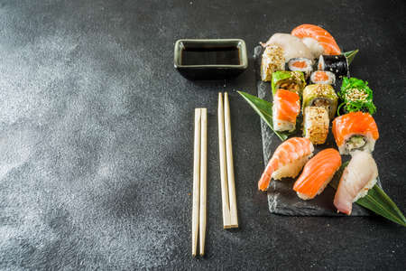 Assorted sushi set on stone or concrete background.  Japanese classic sushi, sushi nigiri. rolls, soy sauce, ginger, chopsticks. Top view. copy spaceの写真素材