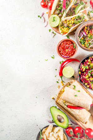 Cinco de Mayo food.Mexican food concept background with taco, quesadilla, burrito, chili, salsa sauce, hot pepper, lime. Black concrete background top view copy spaceの写真素材