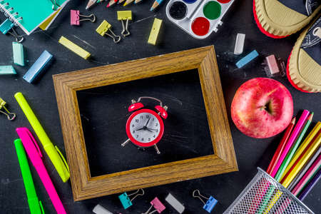 School education supplies on black chalkboard backdrop. Back to school concept. Top view flat lay with copy space for your textの写真素材