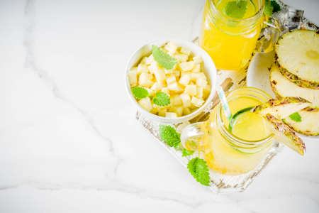 Cold pineapple mojito cocktail with ice, lime and mint, rustic wooden background copy spaceの写真素材