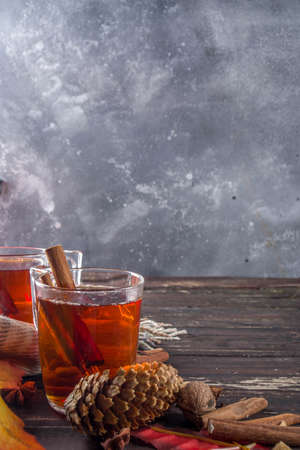 Hot spicy autumn tea with cinnamon, anise, lemon, with autumn decoration, leaves and spicesの写真素材