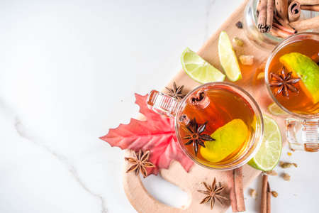 Hot spicy autumn tea with cinnamon, anise, lemon, with autumn decoration, leaves and spicesの写真素材