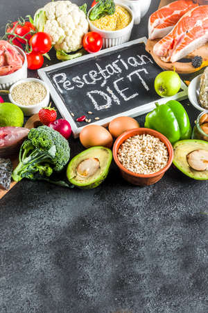 Pescetarian diet plan ingredients, healthy balanced grocery food, fresh fruit, berries, fish and shellfish clams, black stone concrete background copy spaceの写真素材
