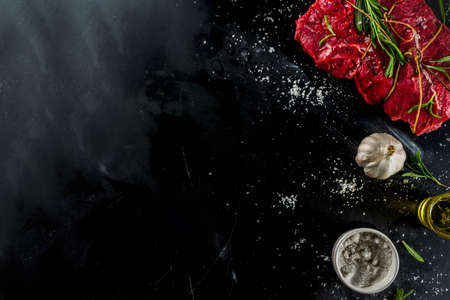 Raw beef tenderloin meat steak, with spices on a black cast iron skillet. Cooking food background.の写真素材