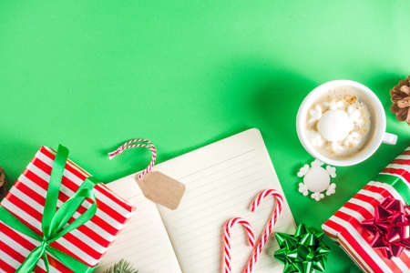Preparation for Christmas background with gifts box, xmas decoration, coffee cappuccino cup and clear notepad for wishes, gift list or to do list. Top view flatlay copy spaceの写真素材