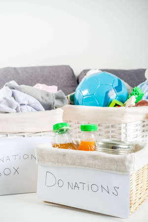 Giving and helping concept. Reuse and recycling theme. Donation box with clothes, children's toys,...