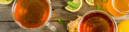 Autumn tea with mint and lemon with ingredients - fresh mint leaves, sliced lemon and honey, rustic wooden background copy space bannerの写真素材