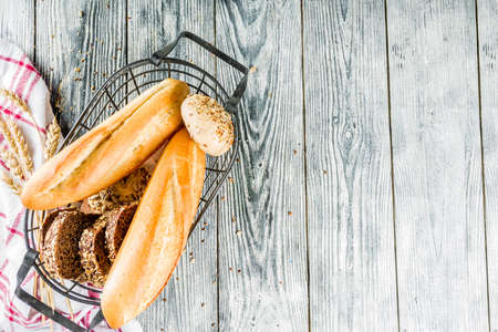 Fresh baked multigrain bread in basket on wooden table. Top view space for textの写真素材