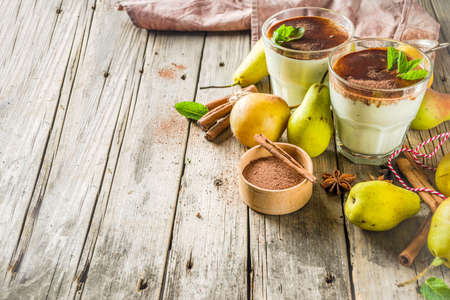 Autumn healthy drinks and snacks. Pear smoothie with cocoa chocolate and spices - cinnamon, anise, with mint leaves. On a rustic wooden background, copy spaceの写真素材