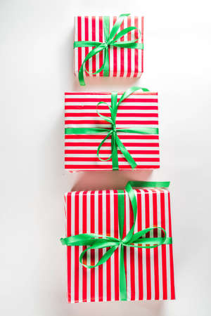 Christmas gift boxes simple pattern background. Festive boxes with Christmas presents, decorated with bright bows with ribbons. Flatlay, above copy spaceの写真素材