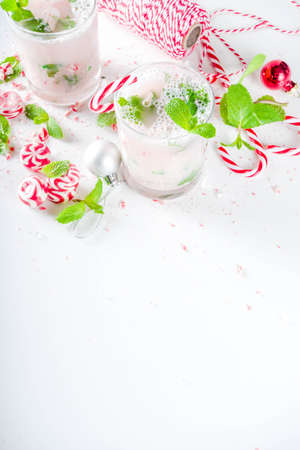Christmas candy cane mojito cocktails with sweet. fresh mint and christmas decoration on white tableの写真素材