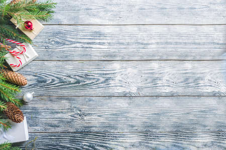Christmas greeting background with Christmas tree branches, traditional decorations, gifts and xmas balls. White wooden background, top view flat lay copy spaceの写真素材