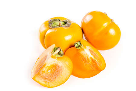 Whole and sliced persimmons, fresh organic farm fruit on a whiteの写真素材