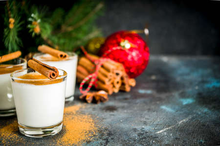 Christmas eggnog liqueur drink or cola de mono cocktail. traditional winter cocktail in short glasses, with xmas decorations, dark background copy spaceの写真素材