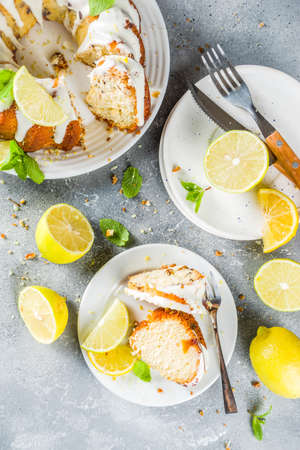 Homemade lemon bundt cake with sugar icing, fresh lemons and mint leaves, copy space