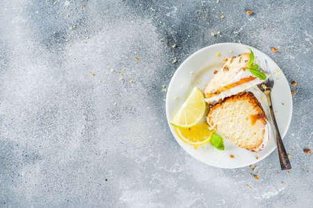 Homemade lemon bundt cake with sugar icing, fresh lemons and mint leaves, copy spaceの写真素材