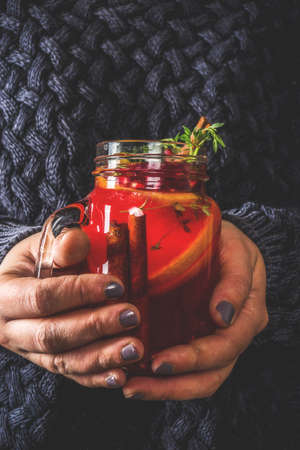 Autumn winter sangria, mulled wine or hot spiced cider cocktails. Red, white and orange hot winter drinks and beverages, in glass mason jar mugs with spices and citrus fruit. Decorated rustic background copy spaceの写真素材